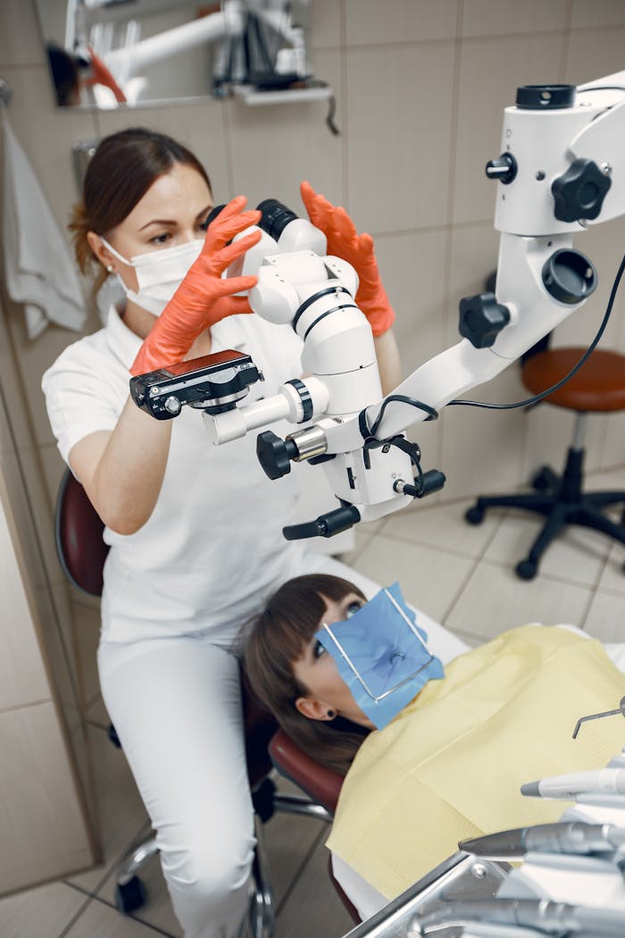Dentist in a clinic performing a dental procedure with advanced equipment on a patient.